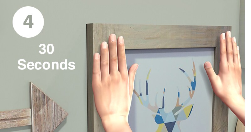 Step 4 of using 3M Command™ strips - remove remaining strip liners and press frame to wall
