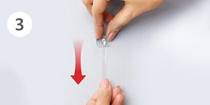 how to remove clear Command™ hooks step3 - stretch strip slowly against the wall 
