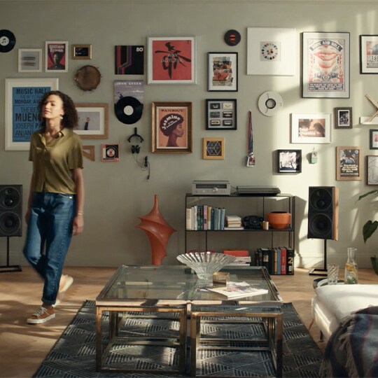 Girl walking away from a wall filled with posters and artworks