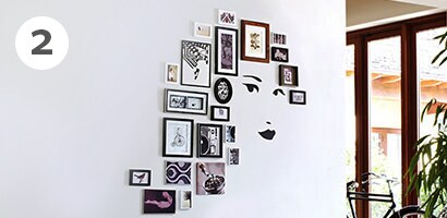 Picture frames surrounding the face decal as a picture gallery wall idea
